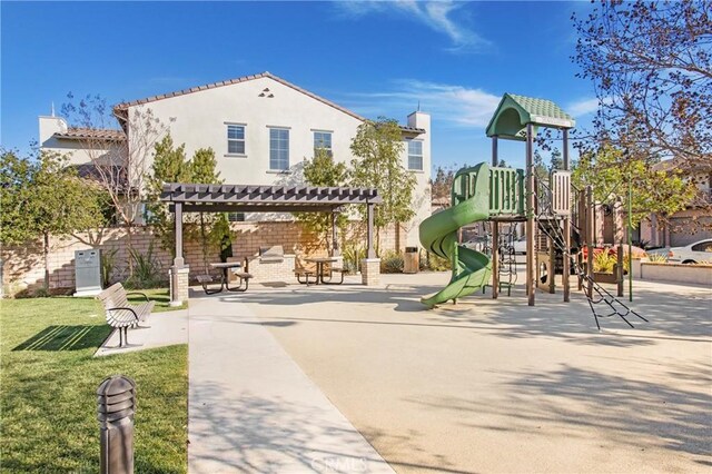 view of play area featuring a lawn and a pergola