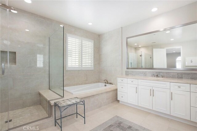 bathroom featuring tile patterned flooring, separate shower and tub, and vanity