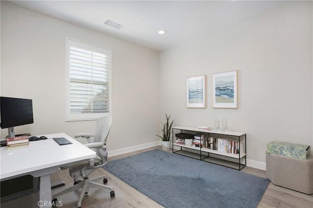 home office with light hardwood / wood-style floors