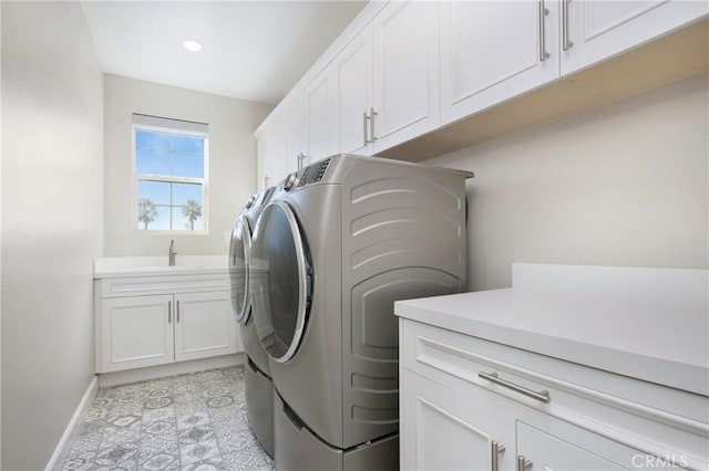 laundry area with sink, independent washer and dryer, and cabinets