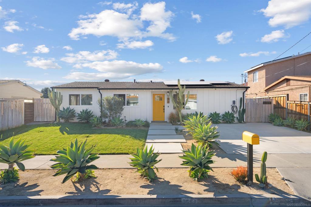 view of front of home featuring solar panels and a front lawn