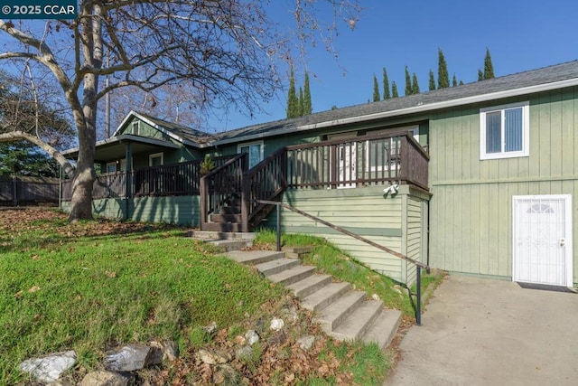 view of front of property with a deck and a front yard