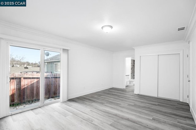 unfurnished bedroom with ensuite bathroom, light wood-type flooring, a closet, and crown molding