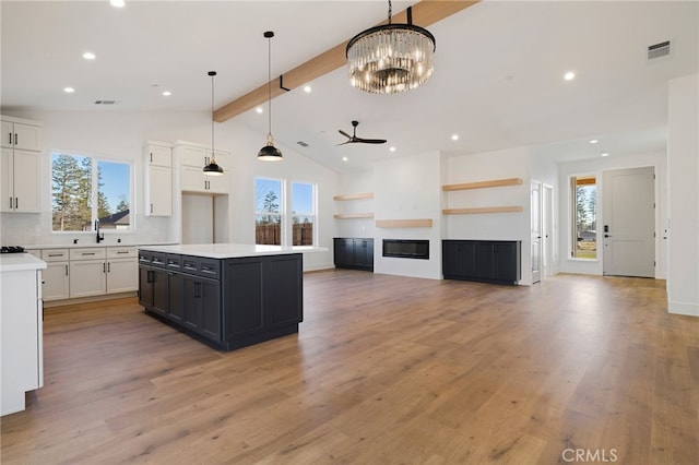 kitchen featuring tasteful backsplash, white cabinets, decorative light fixtures, and a center island