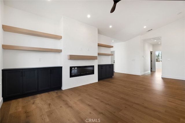 unfurnished living room with ceiling fan, wood-type flooring, and lofted ceiling