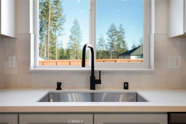 kitchen with sink, backsplash, and white cabinets