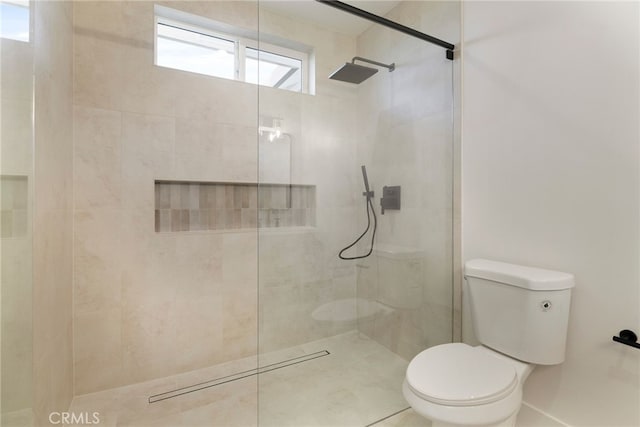 bathroom with toilet and a tile shower