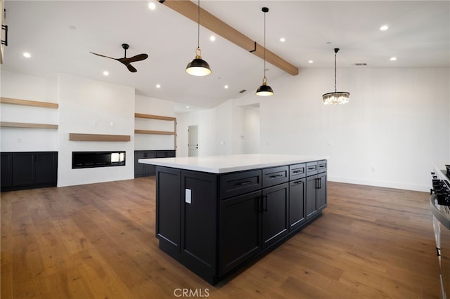 kitchen featuring ceiling fan with notable chandelier, a center island, wood-type flooring, vaulted ceiling with beams, and hanging light fixtures