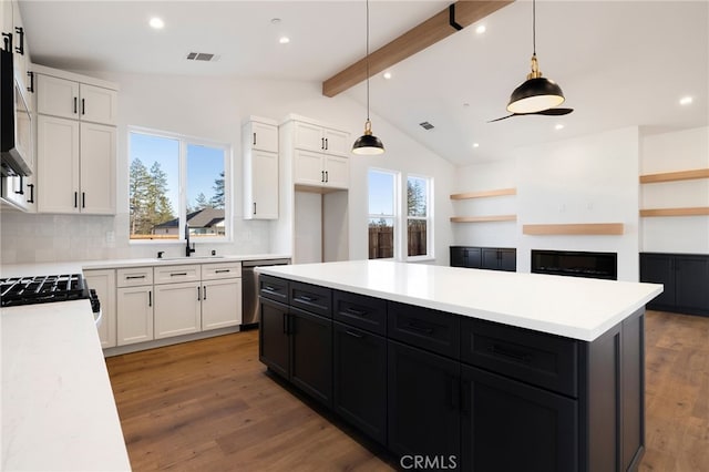 kitchen featuring decorative light fixtures, decorative backsplash, white cabinets, and lofted ceiling with beams