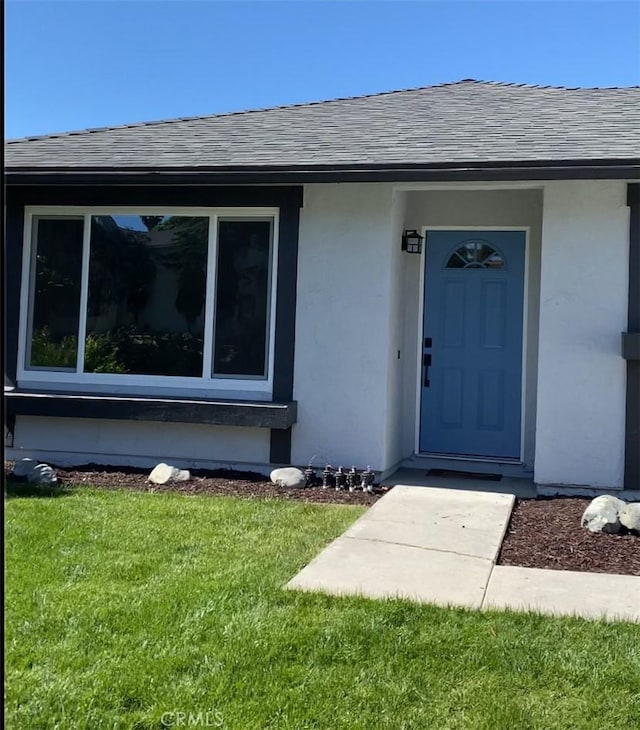 entrance to property featuring a yard