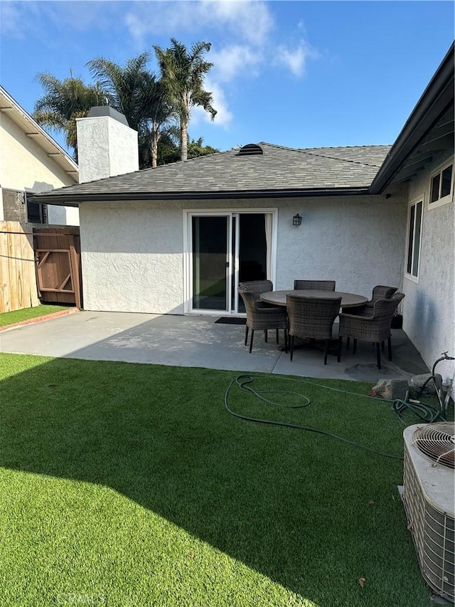 back of property with central air condition unit, a patio, and a yard