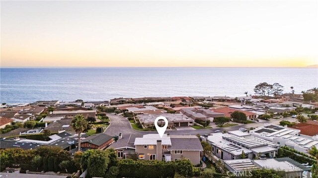 aerial view at dusk featuring a water view