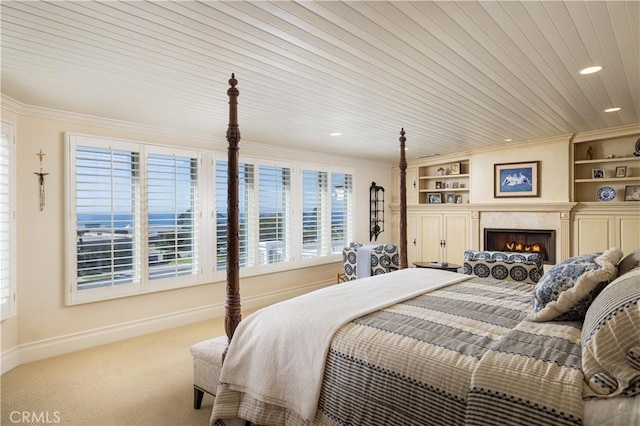 carpeted bedroom with wooden ceiling, crown molding, and a fireplace