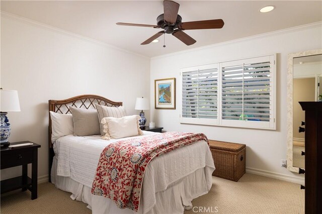 carpeted bedroom with ceiling fan and ornamental molding