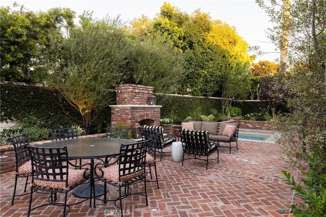 view of patio with an outdoor brick fireplace