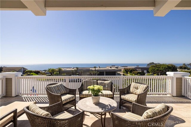 view of patio featuring a water view and a balcony