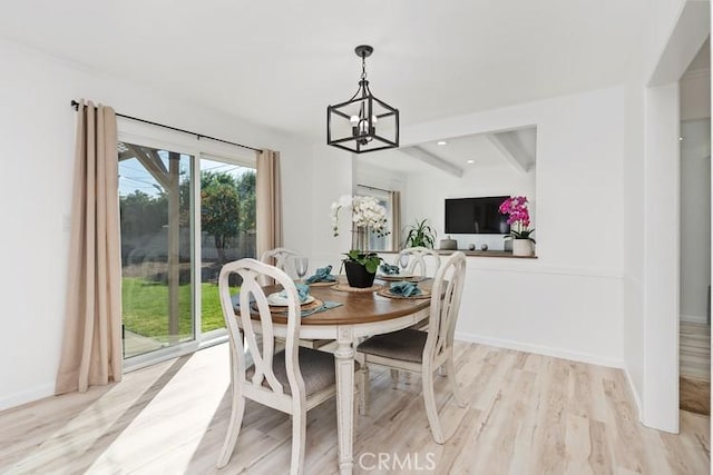 dining space with beam ceiling, a chandelier, and light wood-type flooring