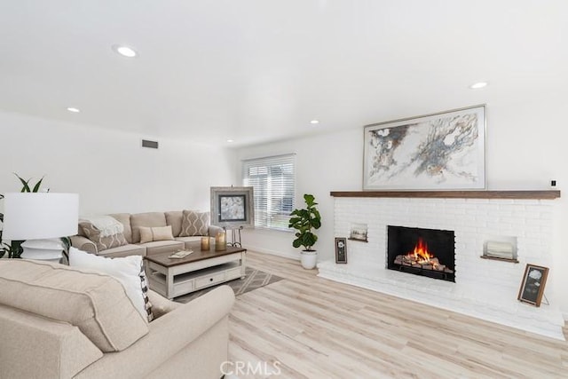 living room featuring a fireplace and light wood-type flooring