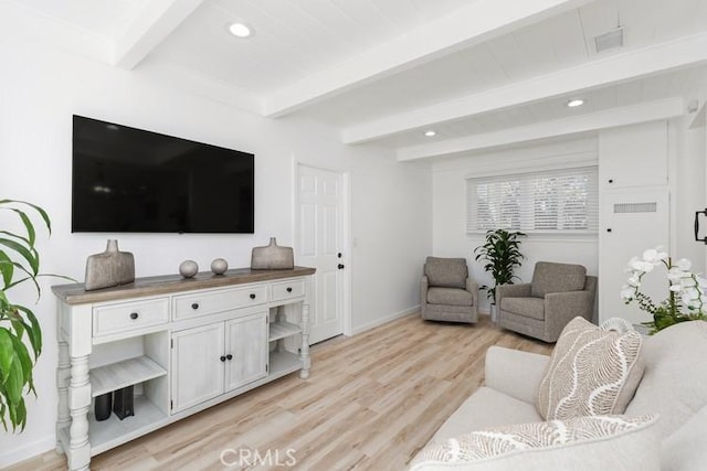 living room featuring beam ceiling and light hardwood / wood-style floors