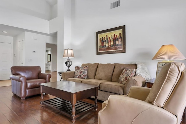 living room featuring a high ceiling and dark wood-type flooring