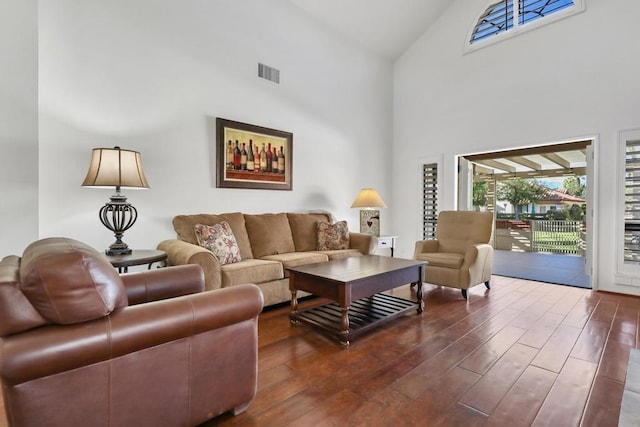 living room with a towering ceiling and dark hardwood / wood-style floors