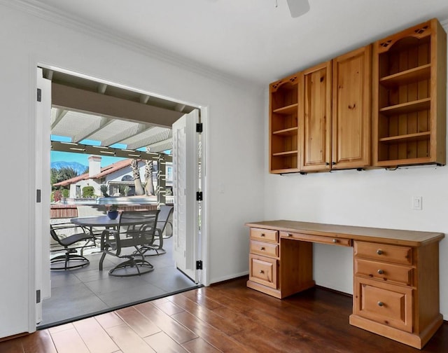 office featuring ceiling fan, dark hardwood / wood-style flooring, ornamental molding, and built in desk