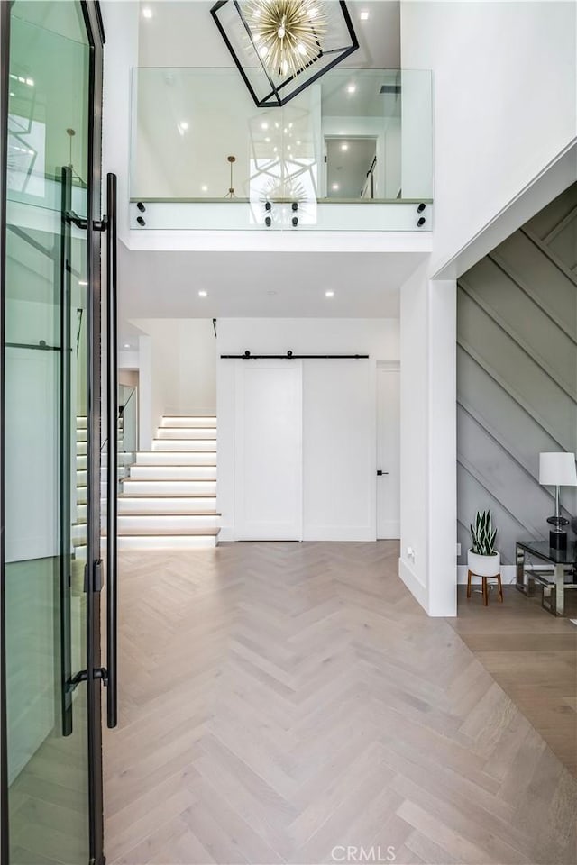 interior space featuring a notable chandelier, a towering ceiling, and light parquet floors