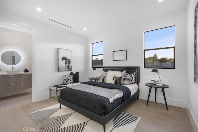 bedroom with light hardwood / wood-style floors, multiple windows, and lofted ceiling