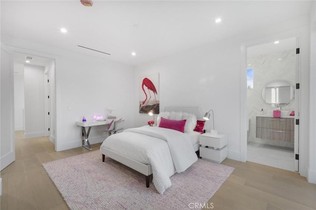 bedroom featuring light hardwood / wood-style flooring and ensuite bathroom