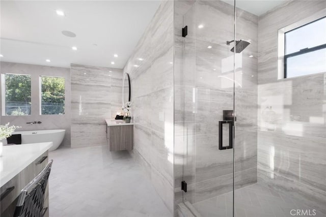 bathroom featuring tile walls, separate shower and tub, and vanity