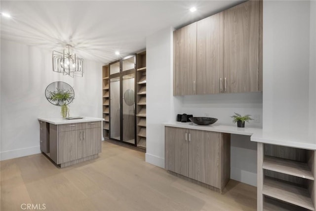 interior space with decorative light fixtures, an inviting chandelier, and light wood-type flooring