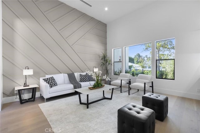 living room with a high ceiling and hardwood / wood-style flooring