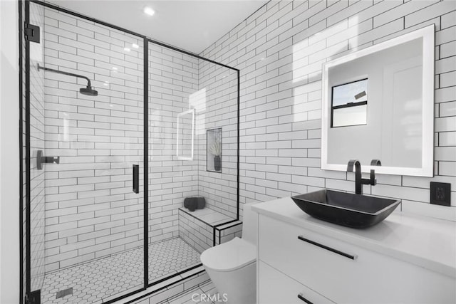 bathroom featuring tile walls, a shower with shower door, toilet, decorative backsplash, and vanity