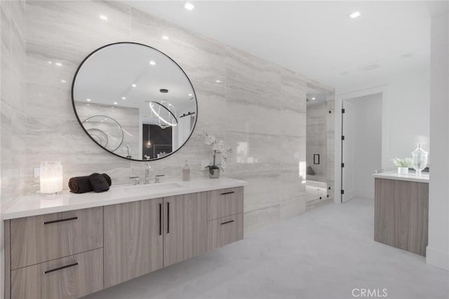 bathroom with vanity, tile walls, and walk in shower