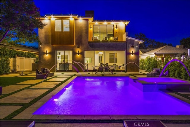 pool at twilight featuring a patio