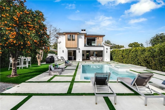 rear view of property with a yard, a balcony, a fenced in pool, and a patio