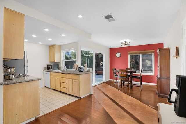 kitchen featuring sink, light wood-type flooring, light brown cabinetry, and white dishwasher