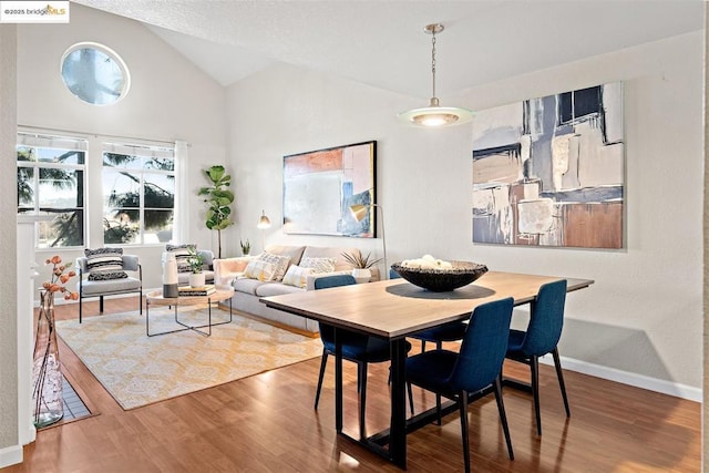 dining area featuring hardwood / wood-style floors and lofted ceiling