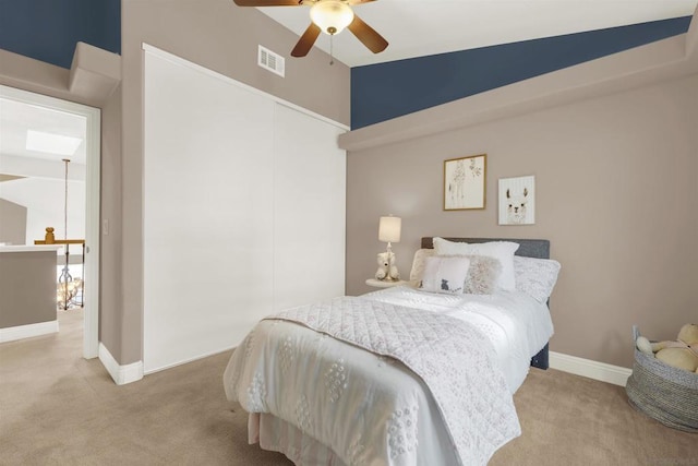 carpeted bedroom with ceiling fan and high vaulted ceiling