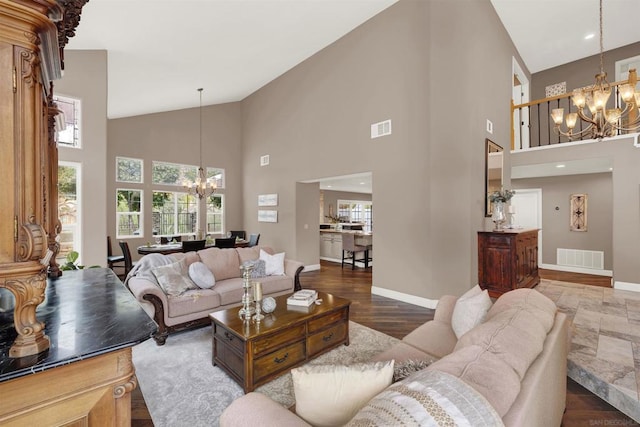 living room with a high ceiling, hardwood / wood-style floors, and a chandelier