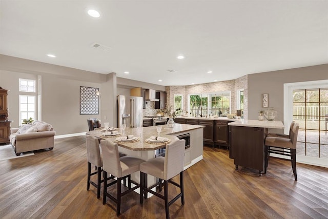 dining space featuring dark wood-type flooring, plenty of natural light, and sink