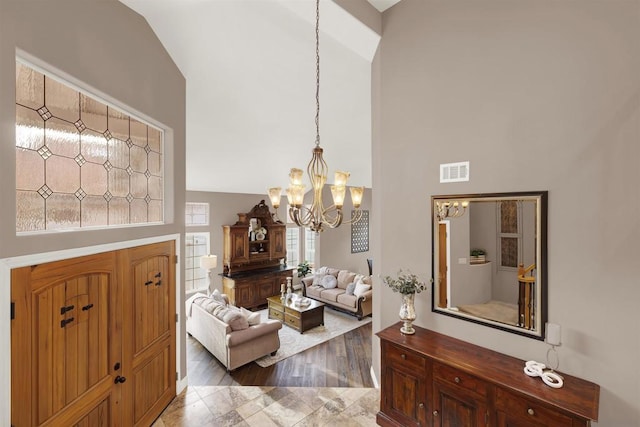 foyer with high vaulted ceiling and a notable chandelier