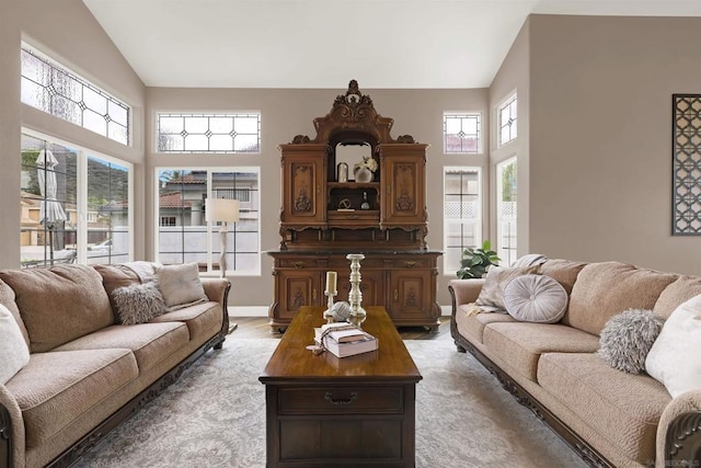 living room featuring high vaulted ceiling and plenty of natural light