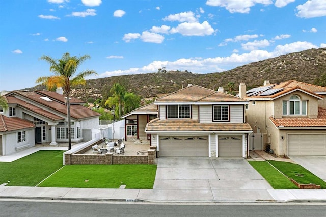 view of front of house featuring a front lawn, a garage, and a mountain view