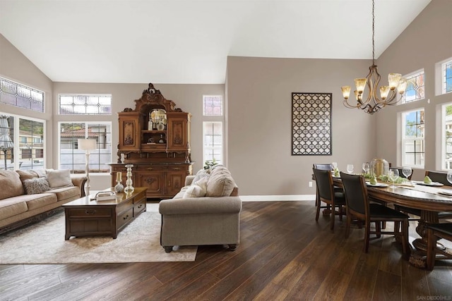 living room with a wealth of natural light, dark hardwood / wood-style flooring, a chandelier, and high vaulted ceiling