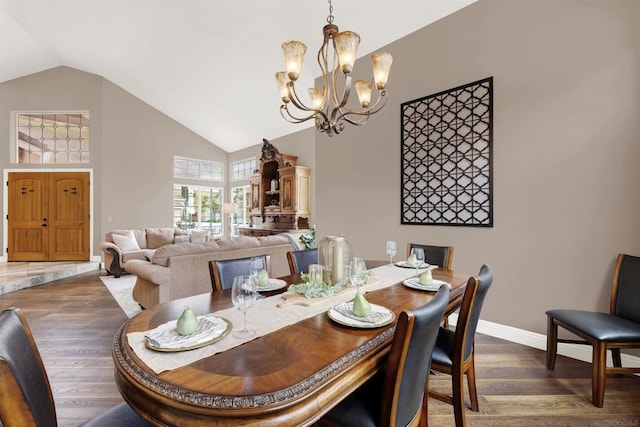 dining area with dark hardwood / wood-style flooring, a notable chandelier, and vaulted ceiling