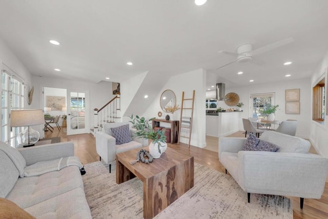 living room featuring plenty of natural light, ceiling fan, and light hardwood / wood-style flooring