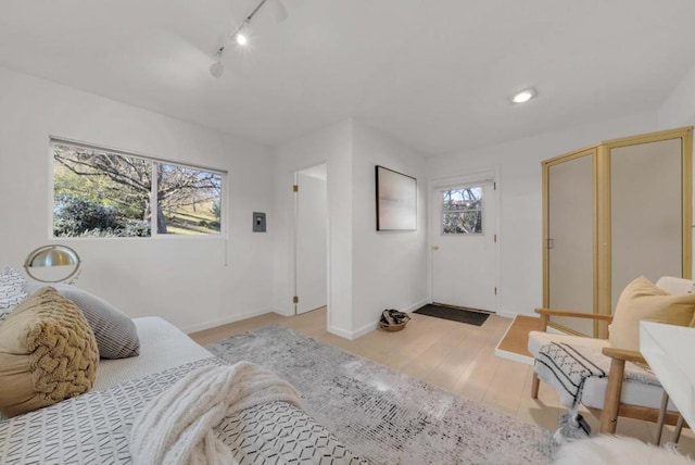 bedroom featuring track lighting and light hardwood / wood-style flooring