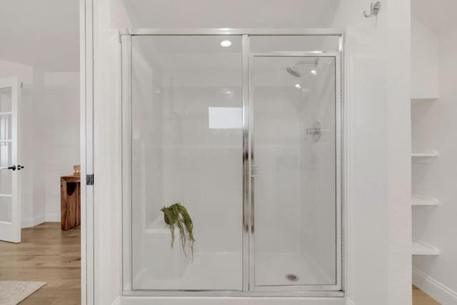 bathroom featuring an enclosed shower and hardwood / wood-style flooring