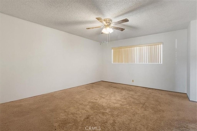 spare room with a ceiling fan, carpet, and a textured ceiling